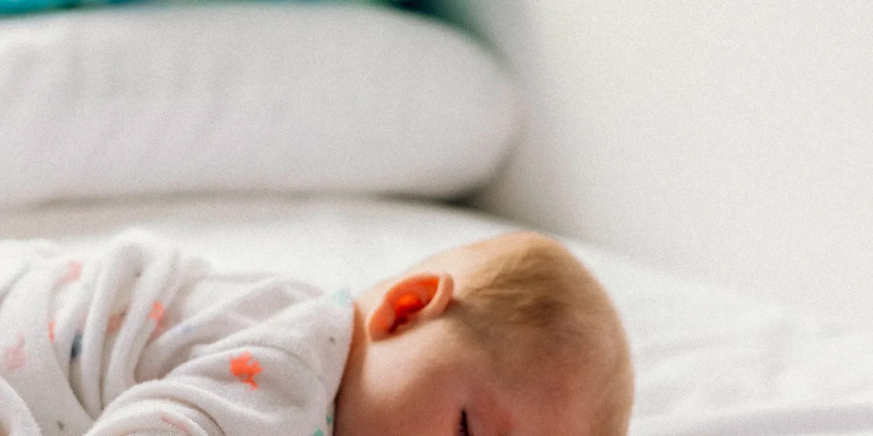 A new parent feeding a baby supported by a wrap-around nursing pillow