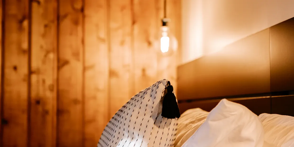 Luxurious silk and cotton sateen pillowcases on a softly lit, neatly made bed